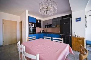 a kitchen with a pink table and a chandelier at Apartment Afitojen in Postira