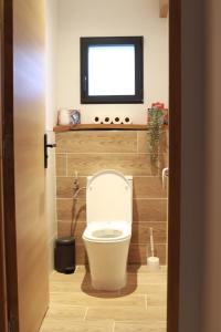 a bathroom with a toilet with a television above it at Maison medocaine familiale in Saint-Sauveur +10 photos