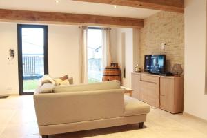 a living room with a couch and a tv at Maison medocaine familiale in Saint-Sauveur
