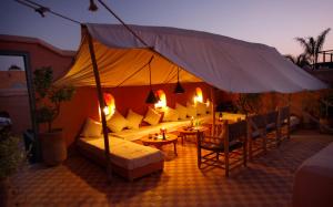 una tenda con un divano, tavoli e sedie di Dar Touyir a Marrakech