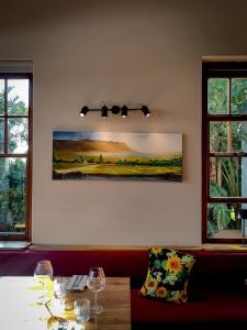 a dining room with a table and two windows at Capelands Resort, Italian Restaurant & Winery in Cape Town