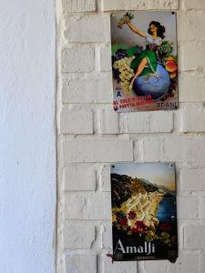 two posters hanging on a brick wall at Capelands Resort, Italian Restaurant & Winery in Cape Town
