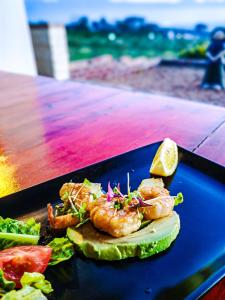 a plate of food with shrimp and a slice of lime at Capelands Resort, Italian Restaurant & Winery in Cape Town