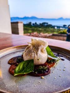 a plate of food with a mushroom and greens at Capelands Resort, Italian Restaurant & Winery in Cape Town