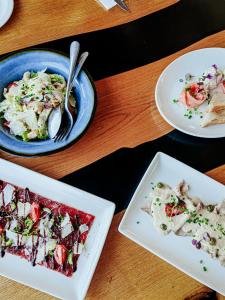three plates of food on a wooden table at Capelands Resort, Italian Restaurant & Winery in Cape Town