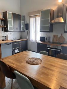 a kitchen with a wooden table and some chairs at La Petite Maison in Montbard