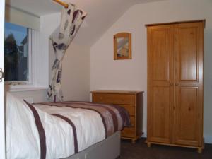 Un dormitorio con una cama y una cómoda y una ventana. en 3 Alexandra Place, Walberswick, en Walberswick