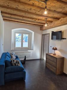 Una sala de estar con un sofá azul y un televisor. en Apartmaji Pr'Pišk, en Bohinjska Bela