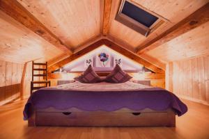 a bedroom with a large bed in a wooden ceiling at Moulin de Record in Ferrières