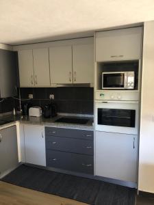 a kitchen with a white oven and a microwave at Casa da Tia Balbina - Medeiros in Medeiros