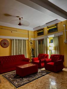 SibsāgarParag Abode - A Luxury Homestay的客厅配有红色沙发和咖啡桌