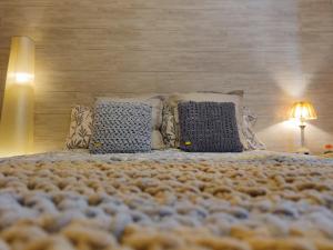 - une chambre avec un grand lit doté d'oreillers et d'une lampe dans l'établissement ALOJAMIENTO MIRABUENOS, à Aranda de Duero