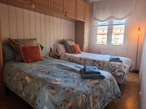 une chambre avec deux lits et une fenêtre dans l'établissement ALOJAMIENTO MIRABUENOS, à Aranda de Duero