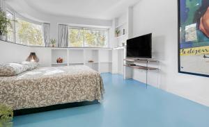 a bedroom with a bed and a flat screen tv at Appartement lumineux proche du Parc des Sources in Vichy