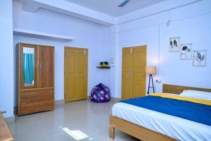 SibsāgarParag Abode - A Luxury Homestay的白色卧室配有一张床和木制橱柜 更多17张照片