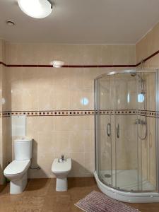 a bathroom with a toilet and a glass shower at Jūras pils - Bulduru 33-27 in Jūrmala +12 photos