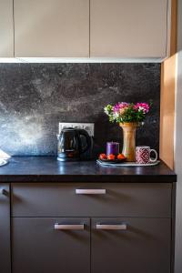 a kitchen counter with a vase with flowers on it at Kikī namiņš in Sigulda +7 photos