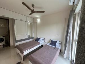 a bedroom with two beds and a ceiling fan at Residential Tranquil in Mumbai +36 photos