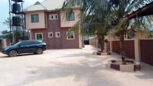 a car parked in a parking lot in front of a house at 2 Bed-Sleeps 4-Free Parking-AirCon-3 in Benin City