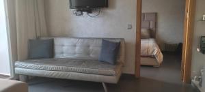 ein Wohnzimmer mit einer Couch und einem Bett in der Unterkunft Les perles de Tamaris in Dar Mohammed Ould Haj Jilali + 7 Fotos