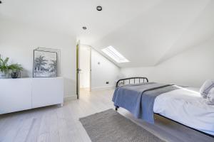 a white bedroom with a bed and a dresser at London Calling 3 bed 3 baths 5 mins from train into City in Winchmore Hill