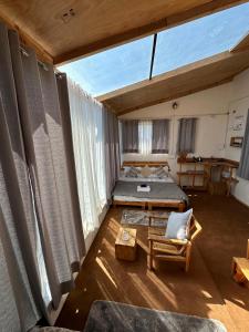 a large room with a bed and a couch at Stargaze with Rio, Glass-Lodge in Thachi Valley in Lārji