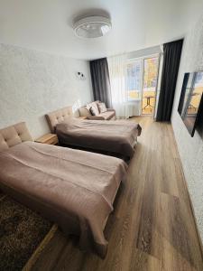 a room with three beds and a couch at Taikos apartamentas in Mažeikiai