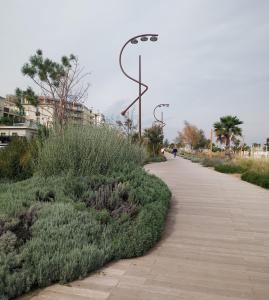 a sidewalk with bushes and street lights on it at 0541 Guest House Rimini in Rimini