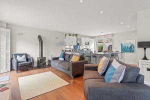 a living room with two couches and a kitchen at House 11 in Looe