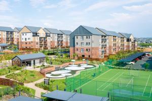 an apartment complex with a tennis court and buildings at 1 Elizabeth Place - Beautiful self catering 2 bedroom unit next to Kyalami Racetrack with free WiFi - swimming pool gym and restaurant - Perfect for a small family in Midrand Waterfall in Midrand