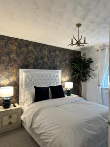 a bedroom with a white bed and two lamps at 3 double bedroom spacious flat in Largs