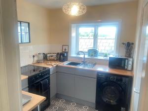 a kitchen with a sink and a washing machine at Hamilton heights in Ellesmere