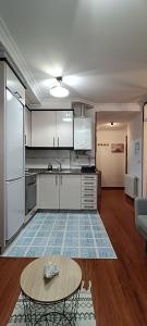 una cocina con armarios blancos y una mesa en una habitación en Bonito apto petfriendly con gran terraza y parking ideal para teletrabajar, en Vigo 18 fotos más