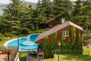 a small house with a swimming pool and trees at Hotel Hita "Nature Experience" for all in Navacerrada