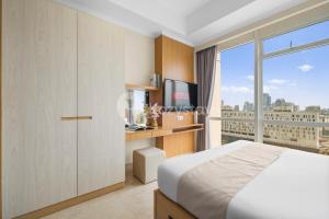 ジャカルタにあるBalsa by Kozystay - Mentengのベッドと大きな窓のある寝室 +27枚の写真