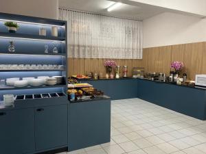a kitchen with a blue counter with food on it at Hotel Ferrari in Rio do Sul