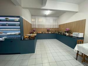a restaurant with a blue counter with food on it at Hotel Ferrari in Rio do Sul