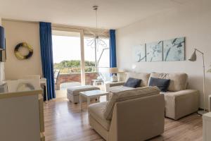ein Wohnzimmer mit Sofa und Tisch in der Unterkunft Duinerei appartement C102 in Callantsoog