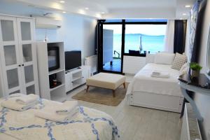a bedroom with two beds and a balcony with the ocean at Bambu Urla Otel in Urla