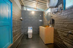 a bathroom with a toilet in a room at SaffronStays Fairytale Villa - 3 bedroom villa in orchards and access to the river in Gushaini