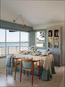 a dining room with a table with a view of the ocean at Wishome-La casa más especial de Oyambre, Comillas in San Vicente de la Barquera