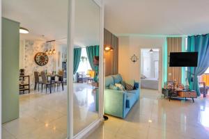 a living room with a blue couch and a dining room at LUXORY DREAMY SUNSET, SeaFront, Direct Access To The Promenade,Wifi,Pool,Free Parking in Los Cristianos