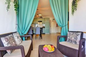 a living room with two chairs and a table with a bowl of fruit at LUXORY DREAMY SUNSET, SeaFront, Direct Access To The Promenade,Wifi,Pool,Free Parking in Los Cristianos