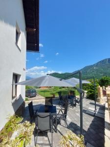 Un patio con una mesa y sillas y una sombrilla. en Apartmaji Pr'Pišk, en Bohinjska Bela