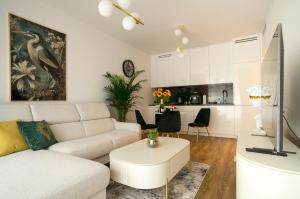 Boulevard Drobnera IV - Apartament nad Odrą - Rynek في فروتسواف: غرفة معيشة مع أريكة بيضاء وطاولة