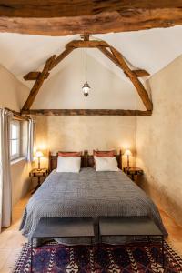 une chambre avec un grand lit dans une pièce dans l'établissement La Chartreuse des Ormeaux maison de maître en Dordogne, à Saint-Alvère