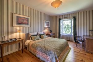 une chambre avec un lit, un bureau et une fenêtre dans l'établissement La Chartreuse des Ormeaux maison de maître en Dordogne, à Saint-Alvère 37 autres photos