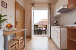 kuchnia ze stołem i widokiem na balkon w obiekcie Apartments Old Stone: w Sukošanie +36 zdjęć