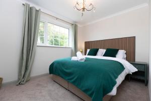 een slaapkamer met een groen bed en een raam bij Hot Tub Free Parking 5 Bedroom Large Space in Darlington +73 foto's