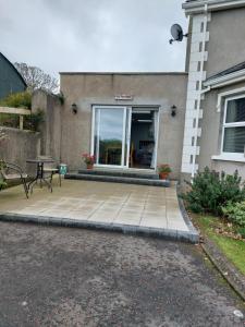 a patio with a table and a bench in front of a house at Sea View Studio in Castlerock